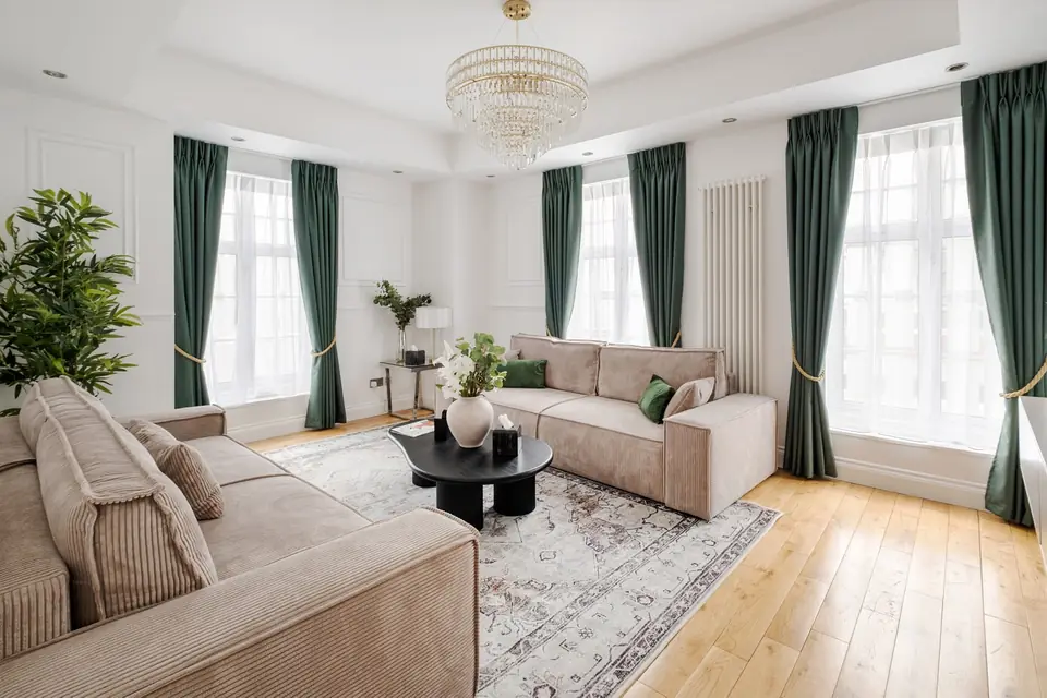 Drawing room with a crystal chandelier and green velvet curtains