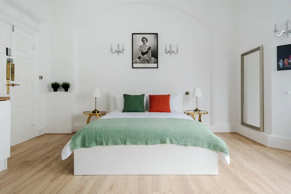 King bed beneath a portrait of Queen Elizabeth II