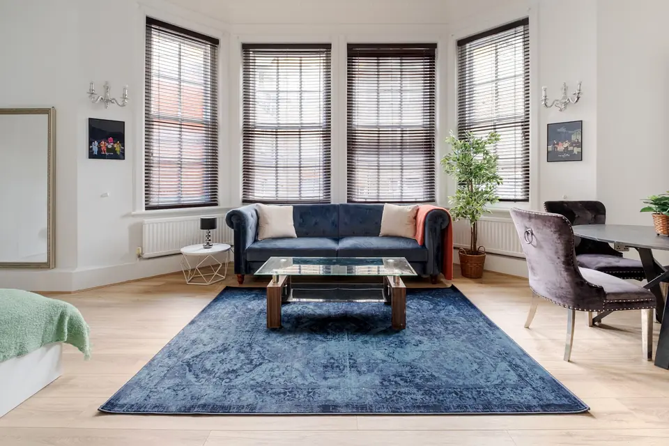 Studio with bay windows and a navy sofa